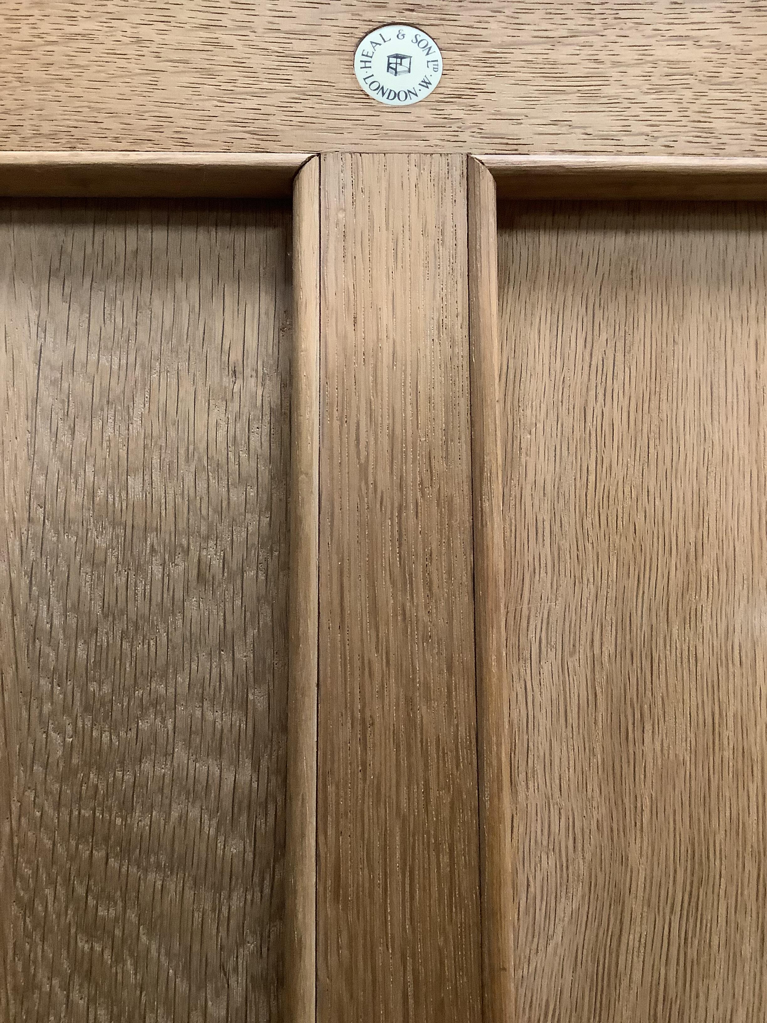 Heal & Son Ltd., London, a pair of bleached oak corner wardrobes, width 94cm, depth 53cm, height 182cm